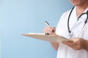 Doctor fills out a form. appointment on medical paper Clipboard-wielding doctor, At the consultation.