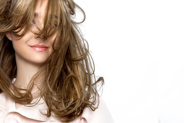 Portrait of a beautiful natural girl with beautiful healthy hair on a white background. A beautiful young girl with a perfect face and beautiful flowing hair. Beauty hair - concept.