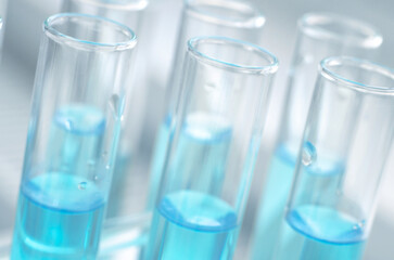 Laboratory test tubes with blue liquid close up, selective focus. Scientific laboratory research and experiments.