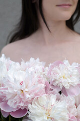 Bouquet of pink peonies in female hands. Unrecognizable woman with bouquet of pink peonies