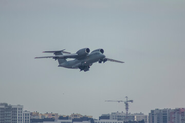 Fototapeta na wymiar A twin-engine military transport jet flies against the sky, photo from below