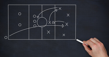 Image of sports tactics over hand with chalk and football field on black background