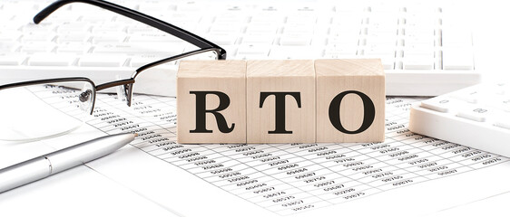 RTO written on wooden cube with keyboard , calculator, chart,glasses.Business concept