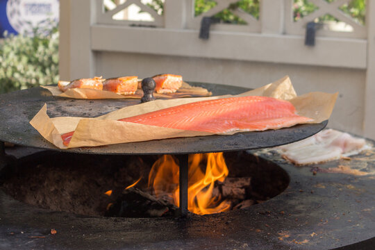 The process of cooking seafood: salmon fish on a brazier. Open fire. Close-up.