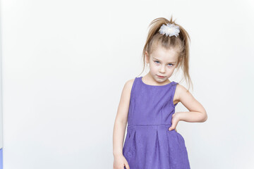 cute 5-6 year old girl in a Violet dress posing in the studio