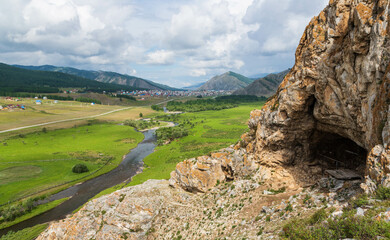 View from the cave in the mountain over the hills, mountains, valley, river and village. Ust-Kansk,...