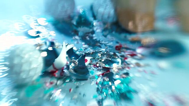 Close-up of feet walking on broken glass toys. Euro sign glare in bokeh. She steps towards the end of the party, gold shoes, high heels. Soft focus motion in blue tint.