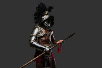 Photo of antique arena fighter of african descent dressed in plumed helmet and armor holding spear.