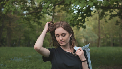 A girl poses by the forest on a warm summer evening.