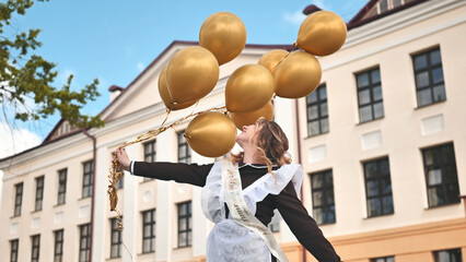 Happy Russian schoolgirl on the last day of school with balloons.