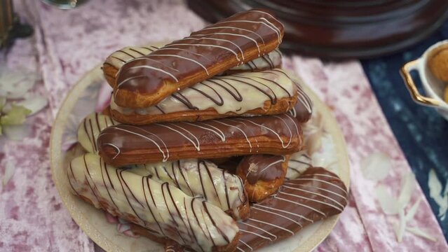 French dessert eclair with white and black chocolate and custard. Traditional French dessert. High quality FullHD footage