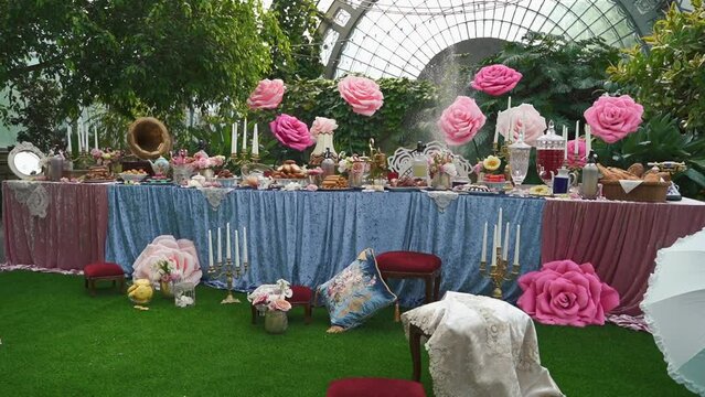 Decor in the style of Alice in Wonderland.Festive table decoration wedding banquet.Interior of a wedding hall decoration ready for guests.Beautiful room for ceremonies and weddings.Wedding concept. 