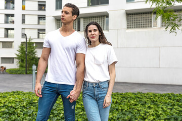 Waist up portrait of happy twosome holding hands and standing in the street