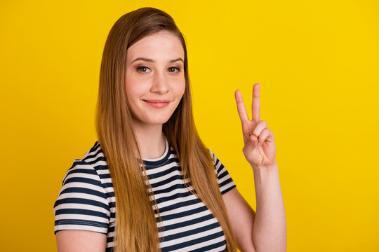 Profile side photo of young cheerful lady show fingers peace cool v-symbol isolated over yellow color background