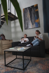 Fototapeta premium Vertical shot of a young boy having tea at home with his mom