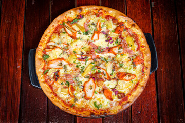 Pizza mit gebratenem Hähnchen, Ananas, Zwiebeln, Kresse und Basilikum