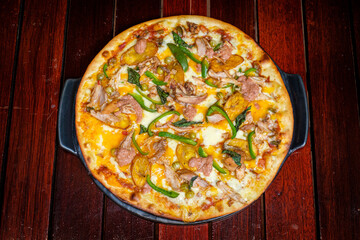 Pizza mit Hähnchen, Banane, Paprika und Basilikum