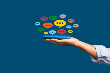 Close-up of hands using mobile phone with colorful chat icons on the application