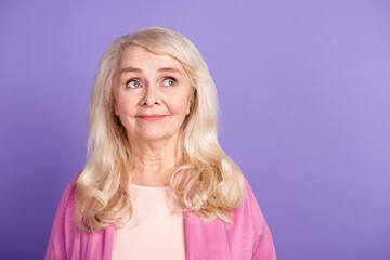 Photo of senior lovely woman curious look empty space minded dreamy isolated over purple color background