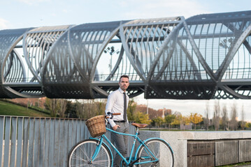 Business man with vintage bicycle by the river