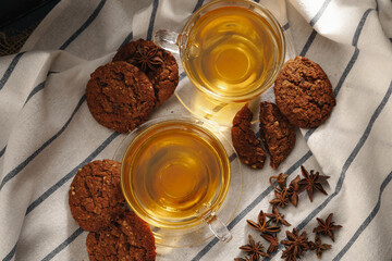 Two cups of herbal tea and cookies on kitchen cloth