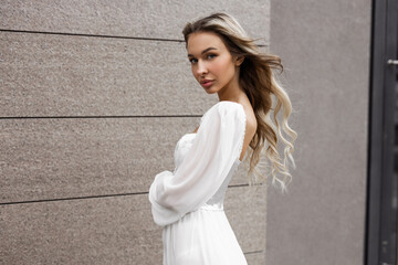 portrait of a beautiful young female with makeup in a white dress	