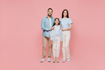 Full body young happy caucasian smiling fun cool parents mom dad with child kid daughter teen girl wearing blue clothes look camera isolated on plain pastel light pink background. Family day concept.