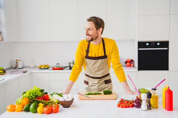 Profile side photo of young handsome man kitchen cook healthy meal fresh vegetables cafe chef indoors