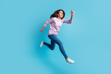 Fototapeta premium Full size profile side photo of young cheerful woman have fun rush speed jump isolated over blue color background