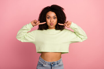 Photo of young lady fooling fingers touch cheeks stupid hold breath comic isolated over pink color background