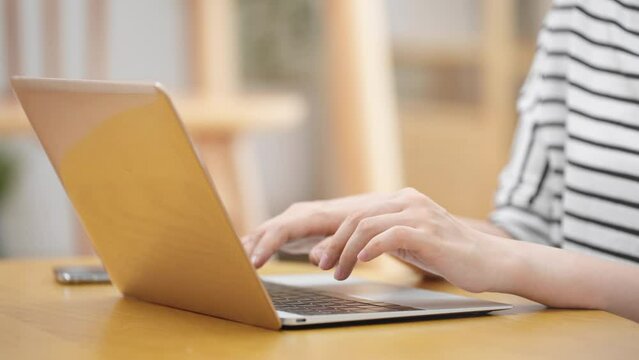 ノートパソコンを操作する若い女性
