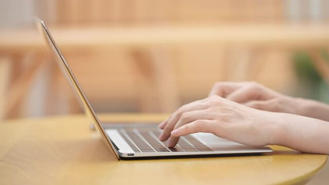 ノートパソコンを操作する若い女性
