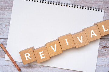 復活・復興のイメージ｜「REVIVAL」と書かれた積み木、ノート、ペン