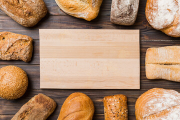 Minimalist wooden cutting board blank mockup on background of Types of homemade bread. Different...