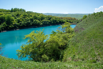 Fototapeta na wymiar Blue karst lake in the mountains in summer