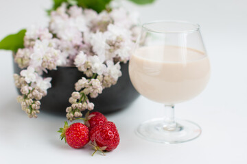 Cottage cheese rings on a platter beautifully decorated with a sprig of lilac. Milkshake with strawberries