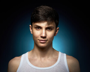 Portrait of a beautiful boy on a black background. Portrait of a young caucasian man. Attractive teenager..