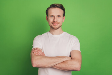 Successful virile attractive business man folded hands isolated on green color background
