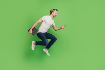 Fototapeta na wymiar Profile photo of sporty businessman hold laptop jump hurry run wear white t-shirt on green color background