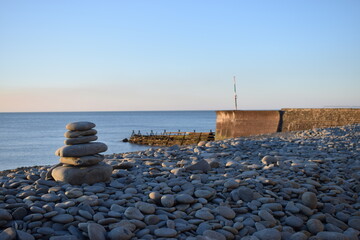 Fototapeta na wymiar Pebble stack at Aberaeron beach and harbour, Wales, UK.