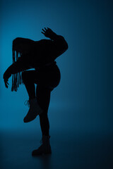 Silhouette of african american woman moving on dark blue background.