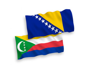 National vector fabric wave flags of Union of the Comoros and Bosnia and Herzegovina isolated on white background. 1 to 2 proportion.