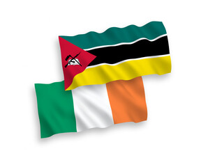 National vector fabric wave flags of Ireland and Republic of Mozambique isolated on white background. 1 to 2 proportion.
