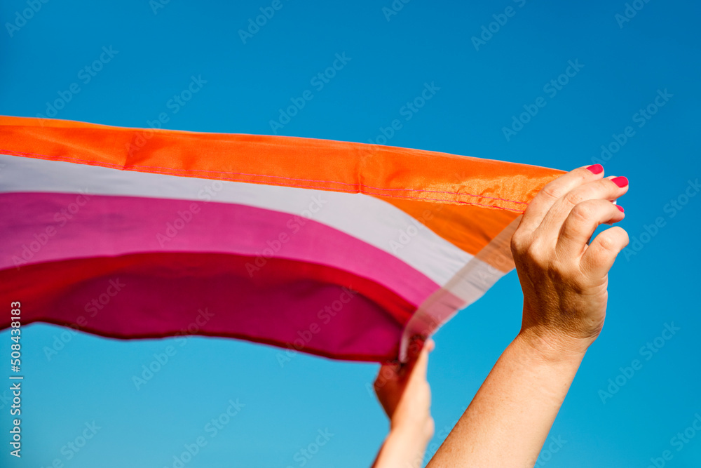 Sticker woman holding a lesbian pride flag outdoors