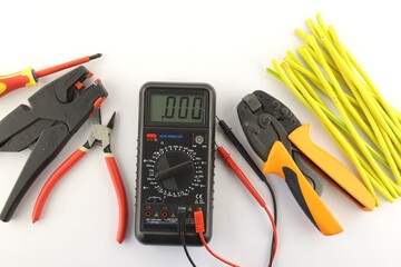 Multimeter and mounting tools on a white background close-up.