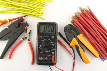 Multimeter and mounting tools on a white background close-up.