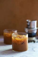 Vietnamese iced coffee, dark roast coffee brewing with sweet condensed milk in glass