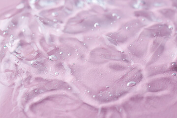 Texture of transparent shower gel on pink background, closeup