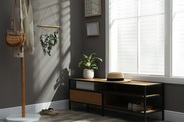 Beautiful decor element made of dry bamboo stick and eucalyptus branches hanging on grey wall in hallway