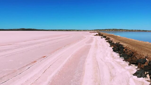 Aerial view overflying along a beautiful Pink salt lake in Australia